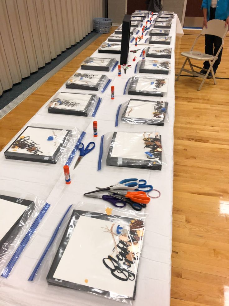 a long table with many items on it and people standing in the background looking at them