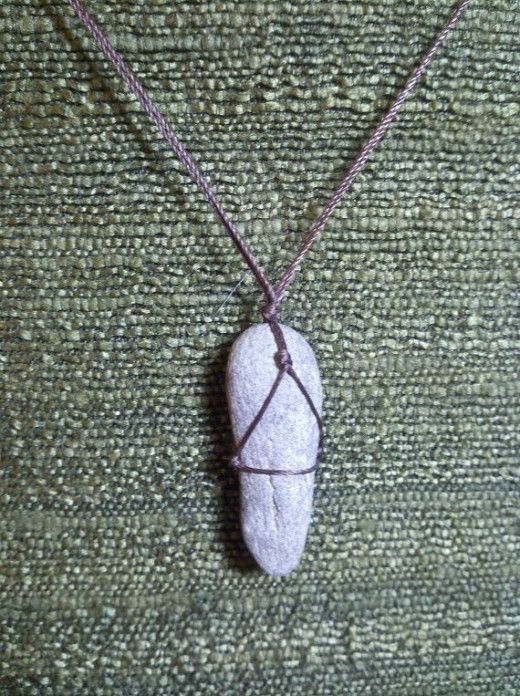 a rock with a wire wrapped around it sitting on a green cloth covered tablecloth