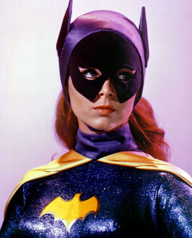 a woman wearing a batman costume with red hair