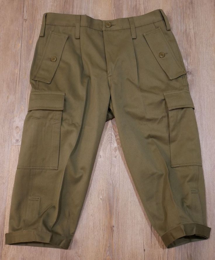 Military pants. Composed of a zipper and a button closure. Two side pockets with flap and buttons. Two velcro pockets at the back. Size: 41cm Length: 75cm Length between legs: 49 cm Weight: 620 grams. Fitted Straight Pants With Flap Pockets, Fitted Khaki Cargo Pants With Patch Pockets, Fitted Military Cargo Pants With Pockets, Khaki Workwear Pants With Flap Pockets, Military Style Full Length Pants With Side Pockets, Military Style Full Length Bottoms With Side Pockets, Khaki Pants With Flap Pockets For Workwear, Military Trousers With Pockets, Military Style Cargo Bottoms For Workwear