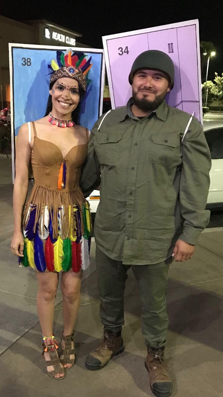 a man and woman standing next to each other in front of a sign with numbers on it