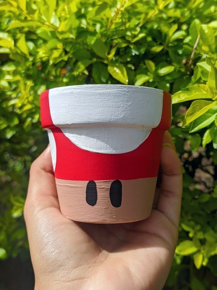 someone is holding up a paper cup that looks like mario