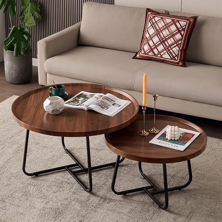 two coffee tables sitting on top of a carpeted floor next to a beige couch