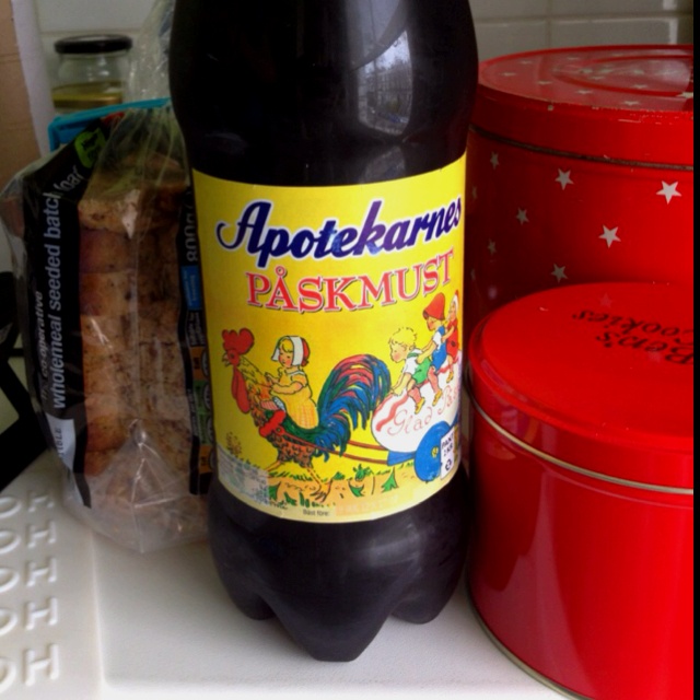 a bottle of beer sitting on top of a counter next to some containers and tins