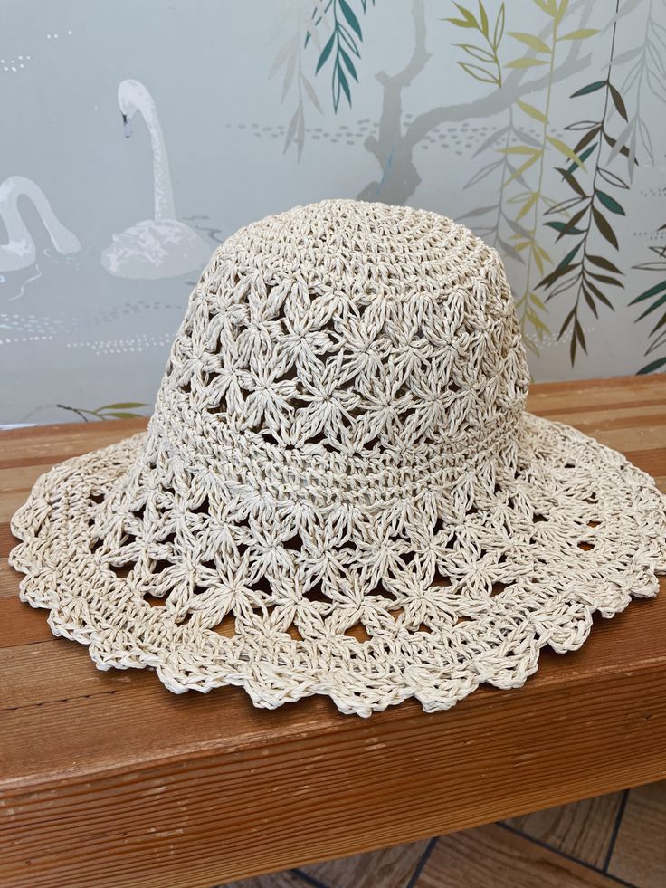 A crochet straw bucket hat. Hat is foldable. Circumference measures 24' White Straw Bucket Hat With Wide Brim, White Wide Brim Straw Bucket Hat, Vacation Crochet Hat With Curved Brim, Lightweight Cream Straw Sun Hat, Adjustable White Straw Bucket Hat, Brimmed Crochet Sun Hat In Natural Color, Lightweight Cream Bucket Hat For Beach, Short Brim Crochet Straw Hat, Crocheted Straw Hat With Short Brim