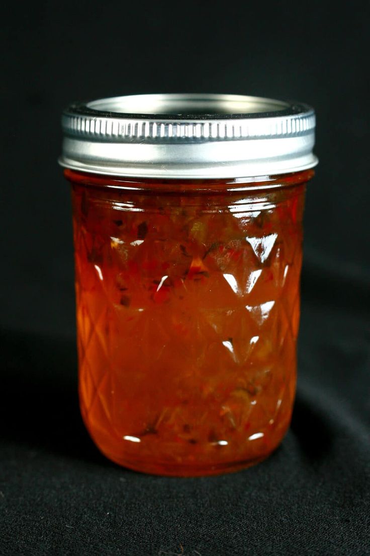 a glass jar filled with liquid sitting on top of a black cloth covered tablecloth