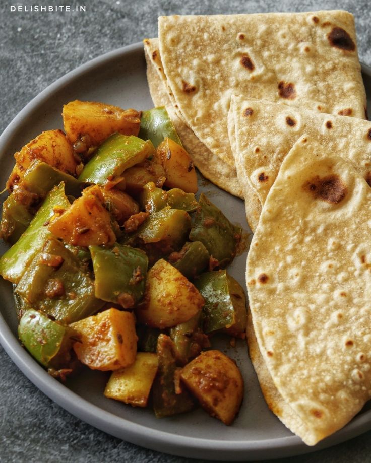 two flatbreads on a plate with vegetables and potatoes next to eachother