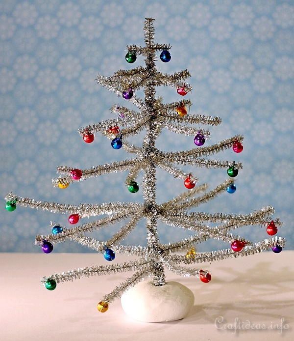 a small silver christmas tree sitting on top of a table