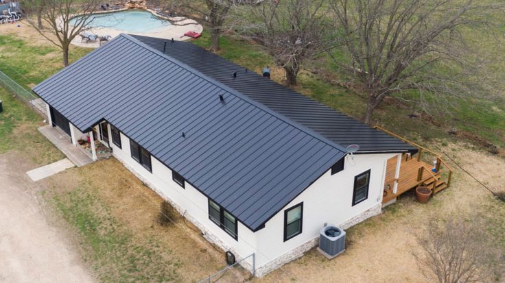 an aerial view of a house with a pool in the background