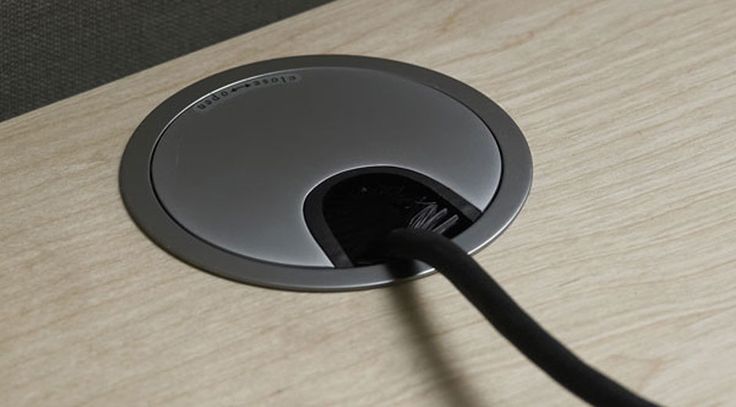 a black cord is plugged in to an electronic device's charger on a wooden surface