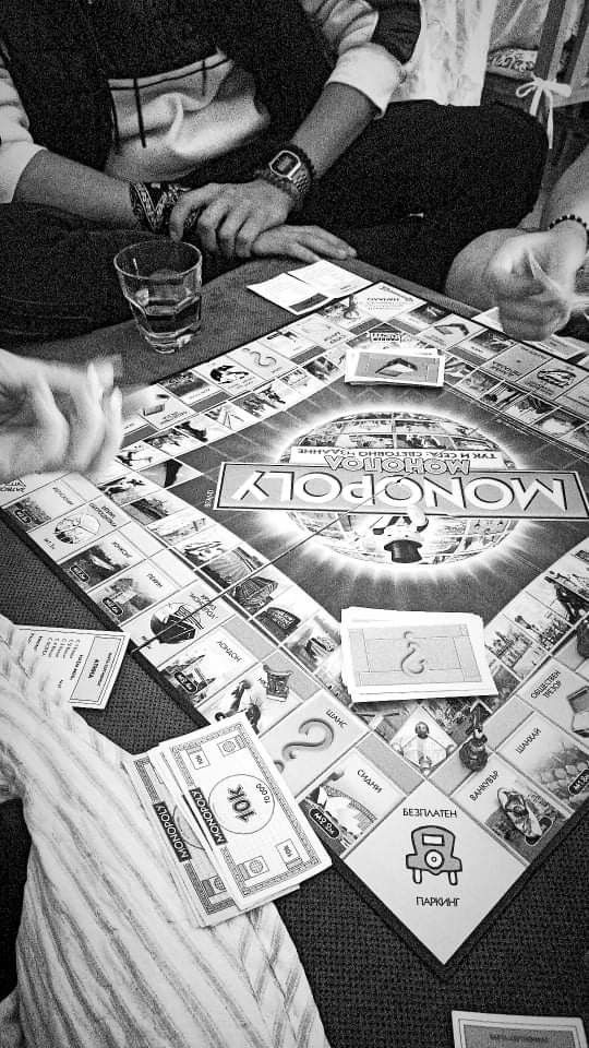 people sitting around a table playing monopoly