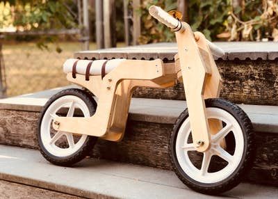 a wooden toy tricycle sitting on the steps