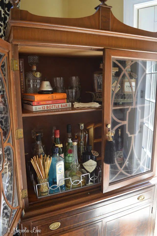 an old china cabinet with liquor bottles and candles