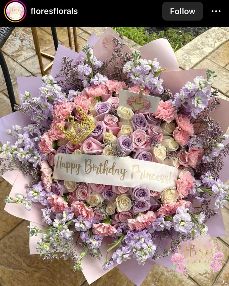 a bunch of flowers that are on top of a table with a happy birthday sign