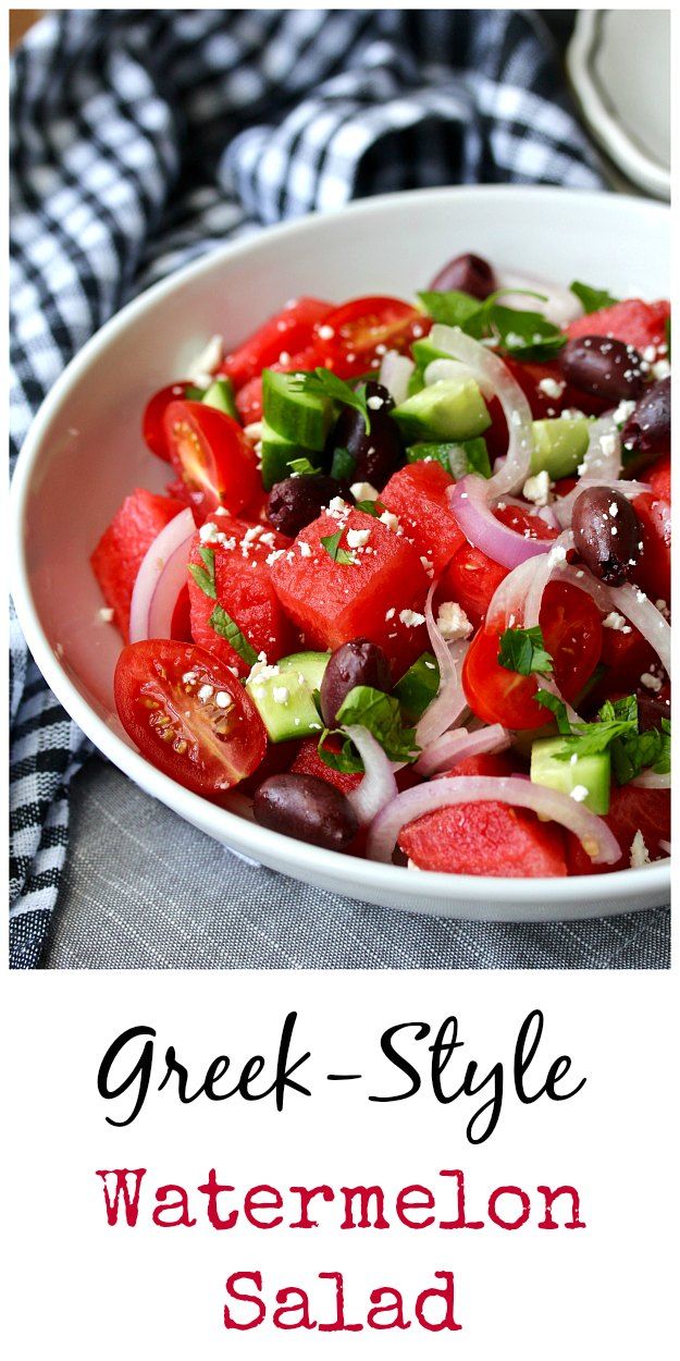 greek style watermelon salad with olives, tomatoes and onions in a white bowl