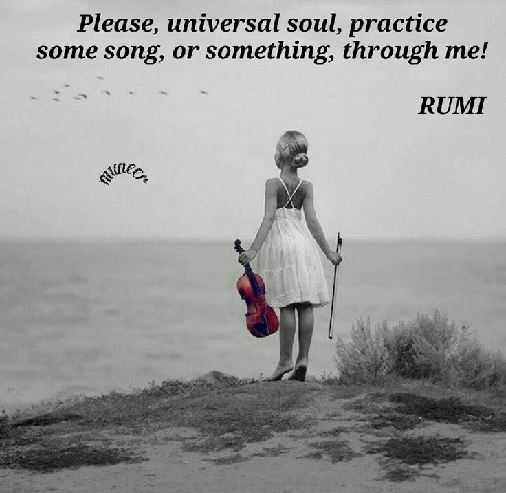 a woman standing on top of a sandy beach next to the ocean holding a violin