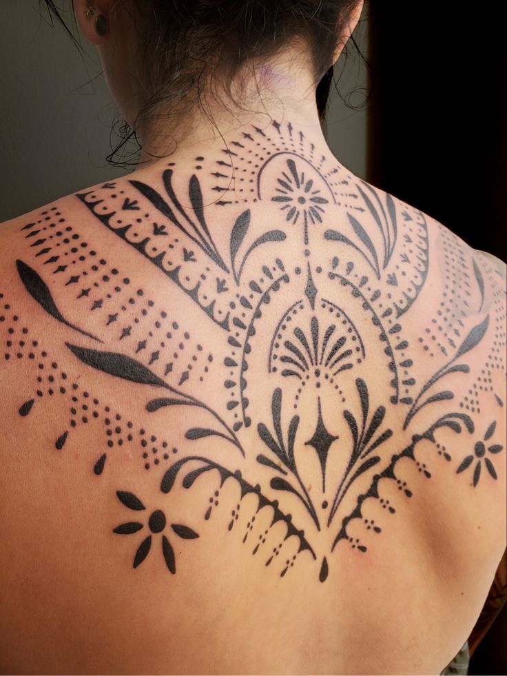 the back of a woman's neck with black and white designs on it,