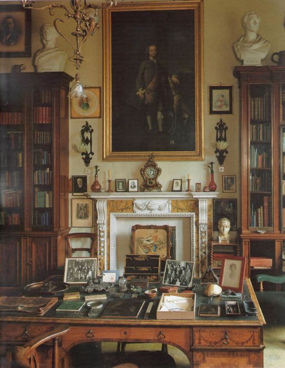 an old fashioned desk with books and pictures on it