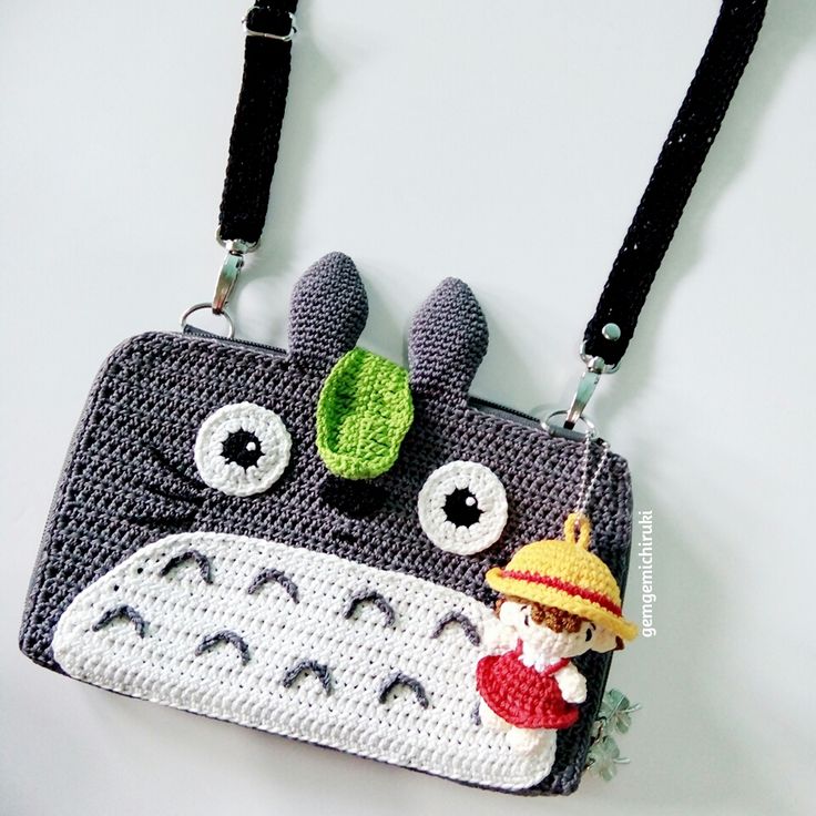 a crocheted purse with an image of a totoro hanging from it