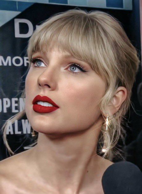 a close up of a person with a microphone in front of her face and wearing red lipstick