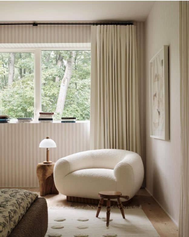 a white chair sitting next to a window in a bedroom