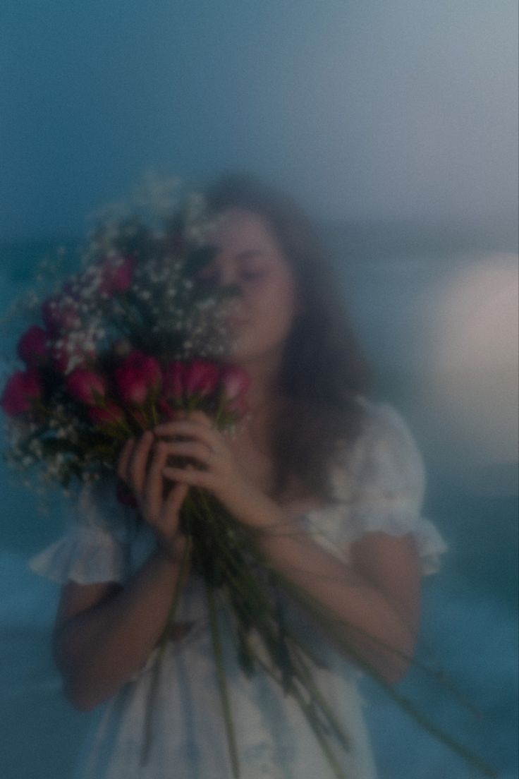 a woman holding flowers in front of her face