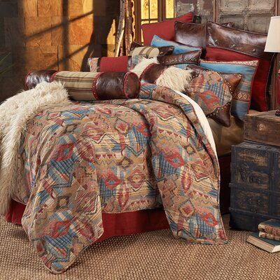 the bed is covered with many pillows and blankets, along with other items on the floor