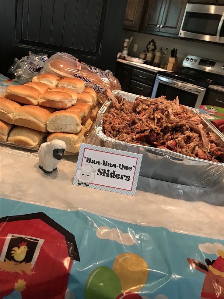 a table topped with lots of food next to a sign that says blue buns and sliders