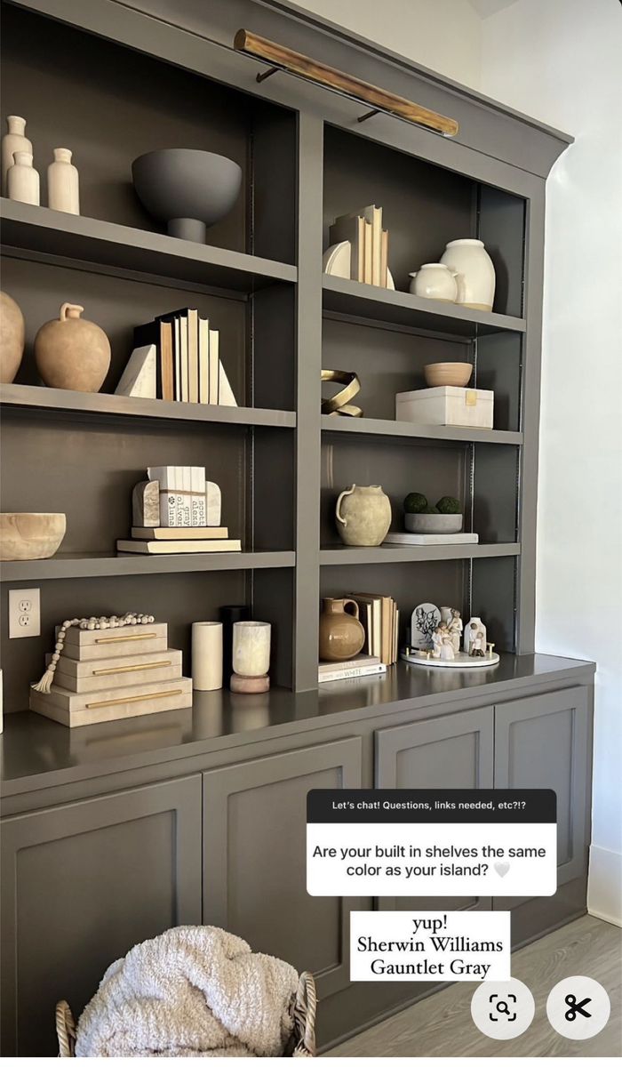 an open bookcase with books and vases on the shelves in front of it