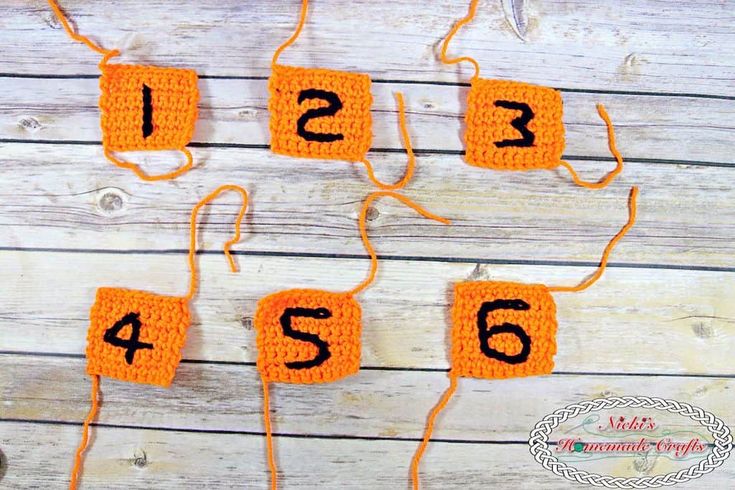 crocheted numbers are arranged in the shape of rectangles on a wooden surface