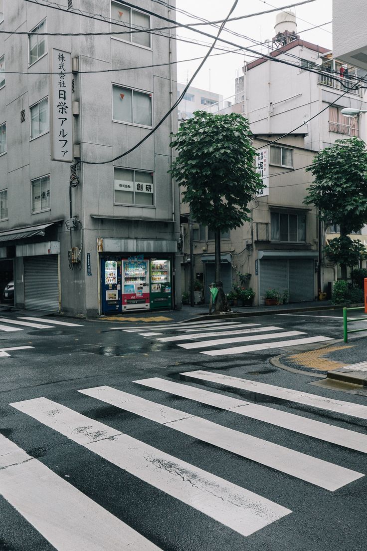 an empty street with buildings and trees in the background