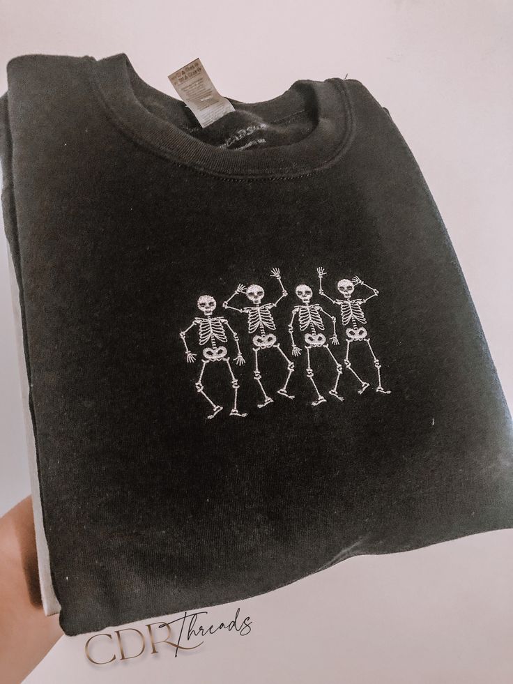 Embroidered Dancing Skeleton Sweater This sweater is a perfect for fall or Halloween! It's a must have for Halloween favorite ! Super soft & cozy with high quality embroidery. Machine embroidered unisex sweatshirt. CUSTOMIZATION - Sweatshirt Color - feel free to message me for any other special requests!! (ex. extra sizes, initials on cuff, etc) FEATURES - 50/50 soft cotton and polyester blend - Double-needle stitching throughout - Embroidered using high-quality thread SIZING Runs true to si Halloween Sweatshirt Skeleton, Halloween Sweatshirt Aesthetic, Black Sweatshirt Embroidery, Embroidered Black Shirt, Halloween Embroidery Designs Sweater, Cute Halloween Sweaters, Halloween Sweaters For Women, Embroidered Fall Sweatshirt, Embroidered Halloween Sweatshirt