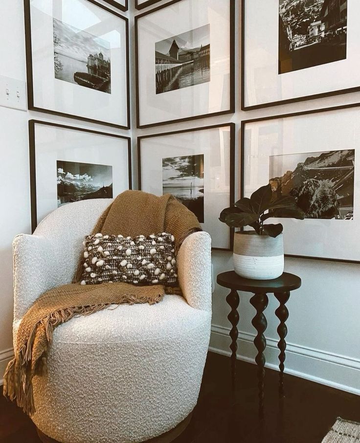 a white chair sitting in front of a wall with pictures on it's walls