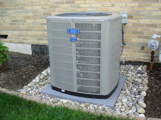 an air conditioner sitting in front of a brick building