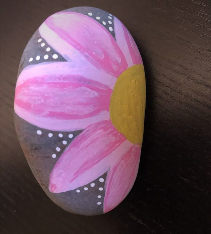 a painted rock sitting on top of a wooden table