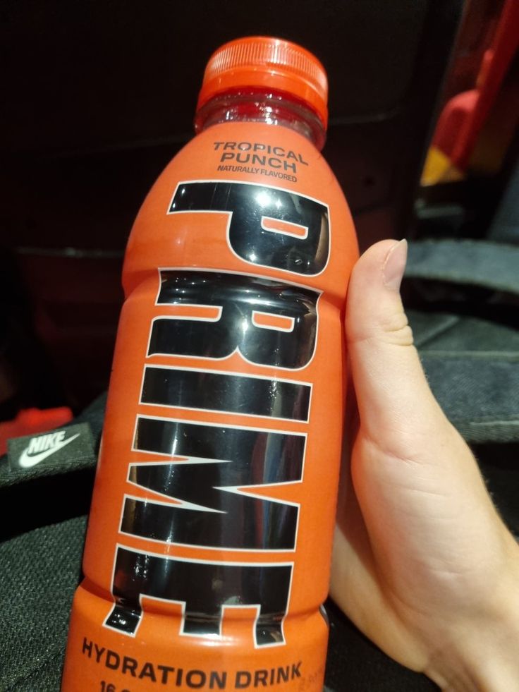 a person holding an orange bottle with the word pump on it's side in their left hand