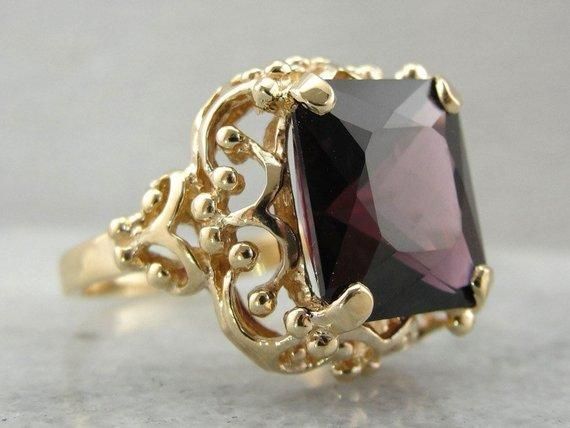 This vintage cocktail ring has lovely details that make it suitable for a spinel. The openwork basket setting lets in plenty of light, while the four sturdy prongs hold even this large stone securely. This particular stone is fantastic! The color is deep true red, with hints of raspberry, and the size is extraordinary. Spinel has a long history as a precious gem. Until modern science developed the ability to truly discern the composition of gems, spinel was considered to be red ruby, and blue sp Yellow Gold Sapphire Ring, Filigree Ring Gold, Red Spinel, Vintage Cocktail Ring, Basket Setting, Spinel Gemstone, Large Stone, Gold Statement Ring, Diamonds And Gold