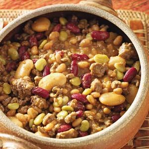 a bowl filled with beans and meat on top of a table