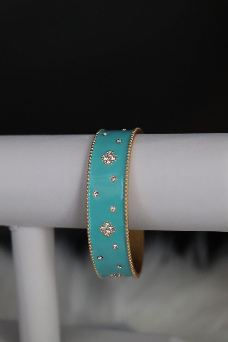 The Turquoise Cuff Bracelet boasts a captivating design with vibrant turquoise stones intricately embedded in a sleek cuff. This accessory effortlessly combines a pop of color with a chic and versatile style, making it a statement piece for any fashion ensemble. Size: 6 3/4 inches - Inner Diameter Closure: Bangle Hinge Bracelet Material: Brass with 18K Gold Plating with Rhodium Coating Lead Free and Hypoallergenic Turquoise Bracelet Jewelry, Turquoise Bracelet Fashion Accessory, Trendy Turquoise Bracelets For Party, Turquoise Fashion Bracelet, Trendy Turquoise Metal Bracelets, Elegant Turquoise Bracelets, Trendy Turquoise Bangle Jewelry, Elegant Turquoise Bracelet For Party, Turquoise Metal Bangle Cuff Bracelet