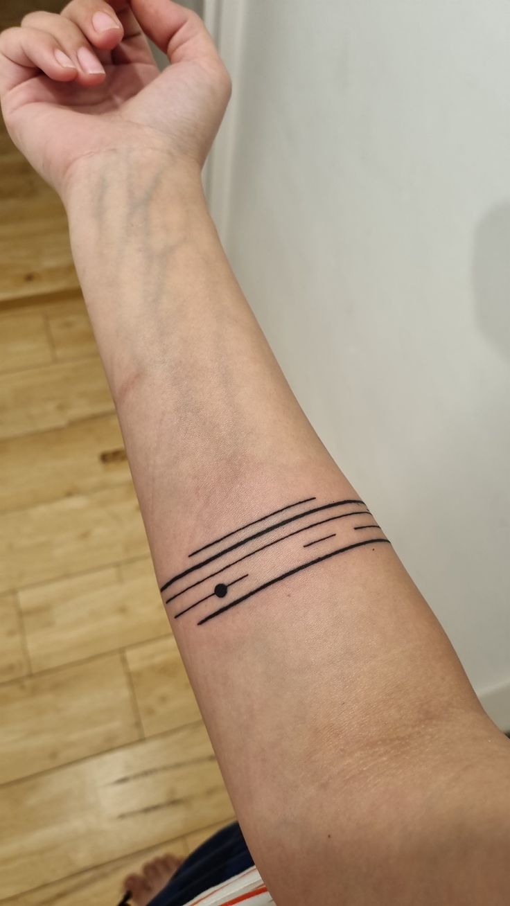 a person's arm with a tattoo on the wrist and two lines across it