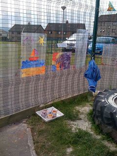 a fenced in area with an old tire and some pictures on it