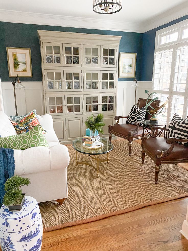 a living room with white furniture and blue walls