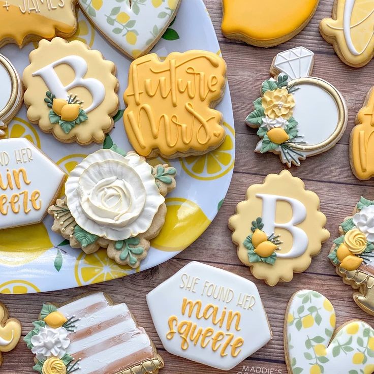 some cookies are on a plate and one is decorated with yellow icing, the other has