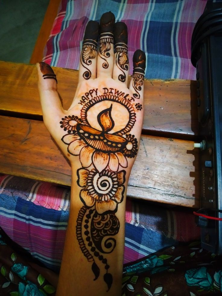 a woman's hand with henna tattoos on it