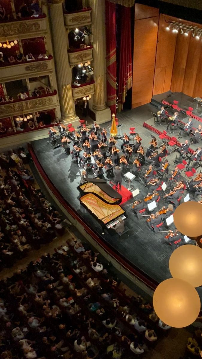 an overhead view of a concert with conductor and orchestra in the middle of the stage