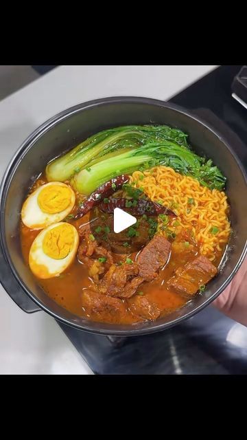 a person holding a pot full of food on top of a stove with broccoli and eggs in it