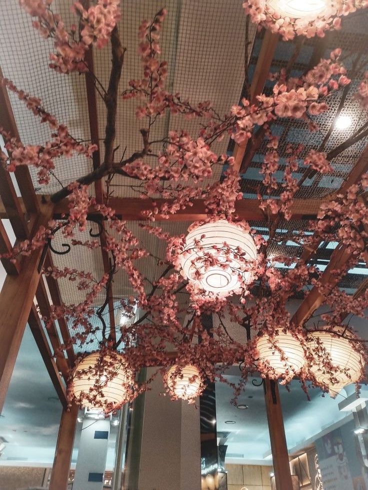 the lights are hanging from the ceiling in the room with cherry blossoms on it, and there is also a chandelier