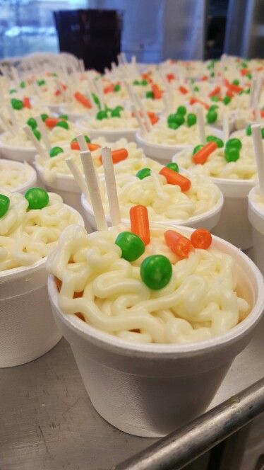 bowls filled with noodles and carrots on top of a table