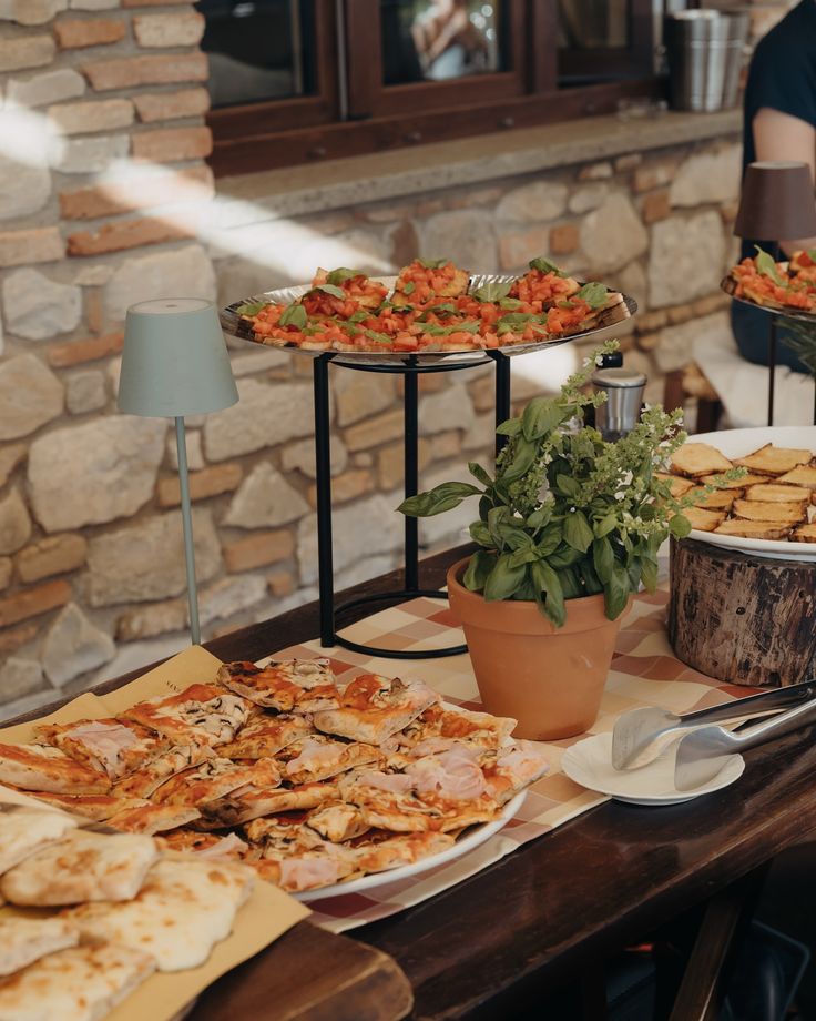 a table filled with different types of pizzas and other food on top of it