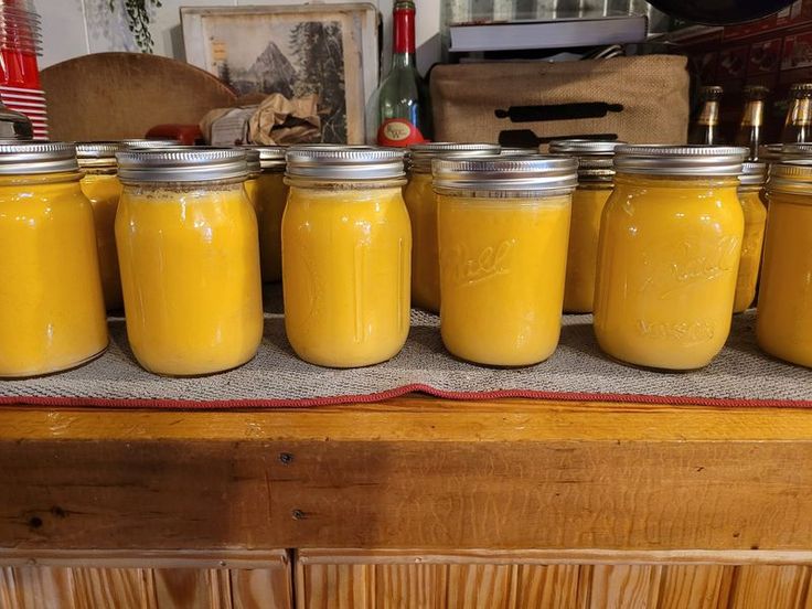 several jars filled with yellow liquid sitting on top of a counter